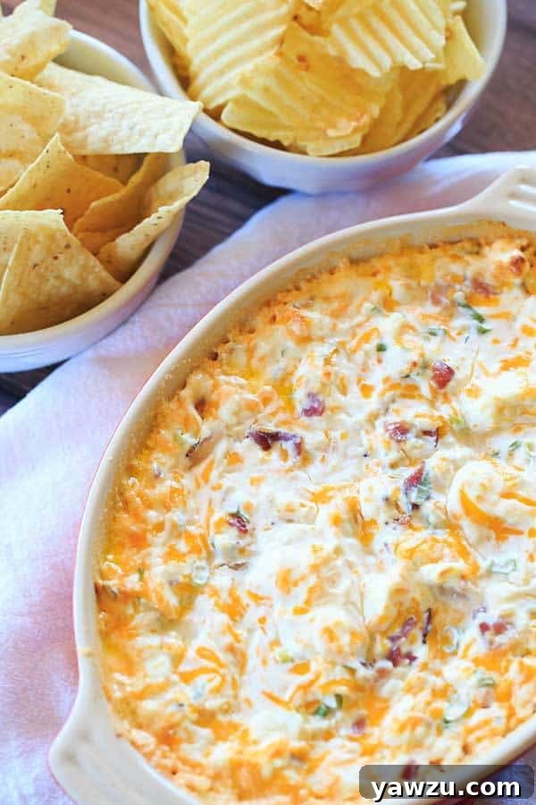 Close-up of bubbling hot cheesy bacon dip in a baking dish, ready for dipping