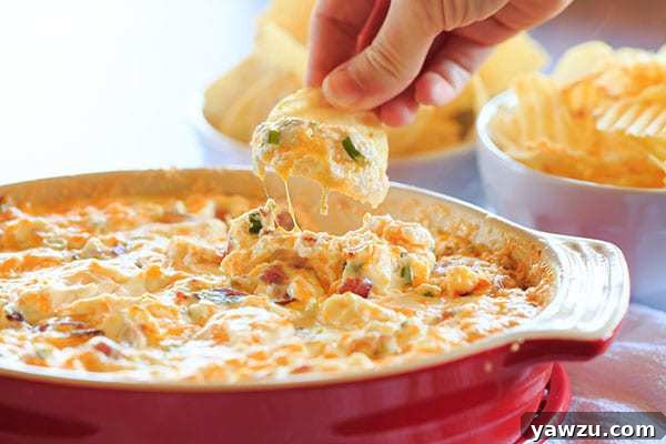 Rustic shot of warm bacon dip with a spoon, highlighting its creamy texture