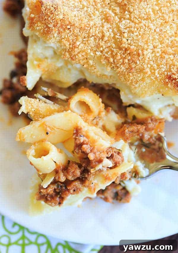 A freshly baked pan of pastitsio, with the top golden-brown and bubbling, garnished with fresh parsley, ready for slicing.