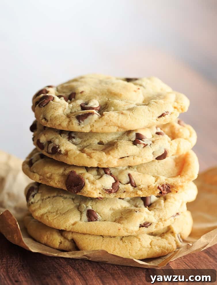 A glorious stack of thick, soft, and perfectly chewy chocolate chip cookies, freshly baked and ready to be enjoyed.