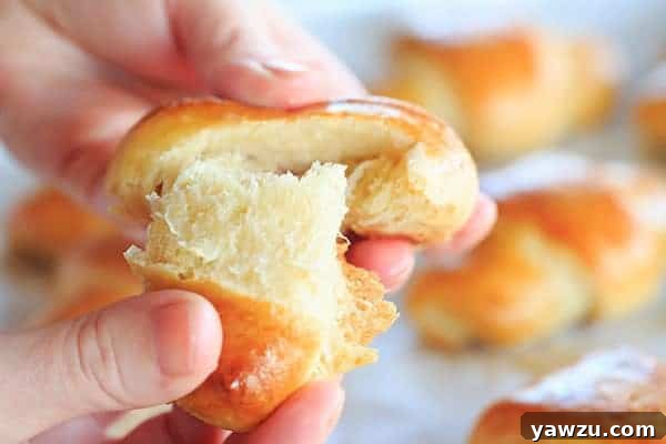 Several golden-brown homemade crescent rolls presented elegantly on a white platter, inviting guests to savor their fresh-baked goodness.