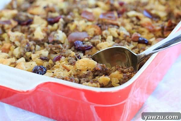 A close-up of a serving of Sausage, Apple & Sage Stuffing, showing its moist texture and golden crust. | https://www.browneyedbaker.com/sausage-apple-sage-stuffing/