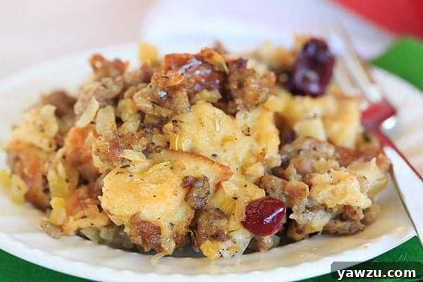 A generous scoop of Sausage, Apple & Sage Stuffing on a plate, garnished and ready for a holiday meal. | https://www.browneyedbaker.com/sausage-apple-sage-stuffing/