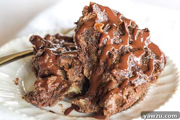 Close-up of baked chocolate bread pudding in a baking dish, showcasing its crisp surface and rich, gooey interior before serving.