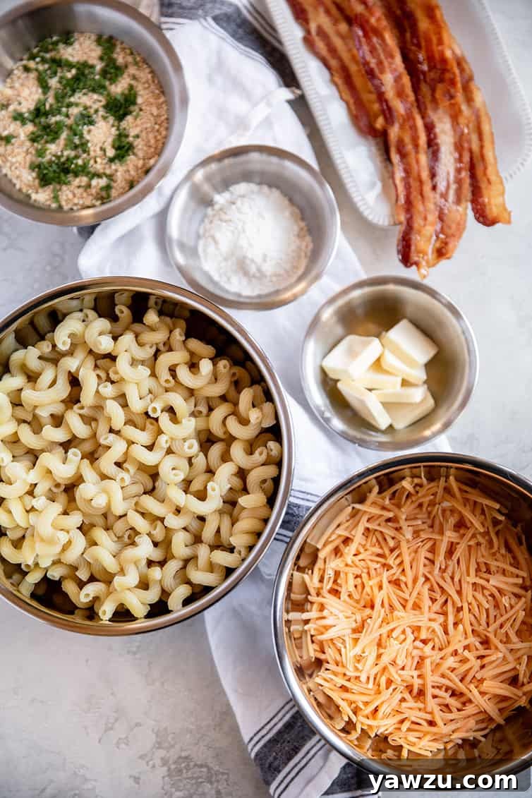 Ingredients for homemade baked mac and cheese prepped in individual bowls, including pasta, cheese, milk, butter, and crackers.