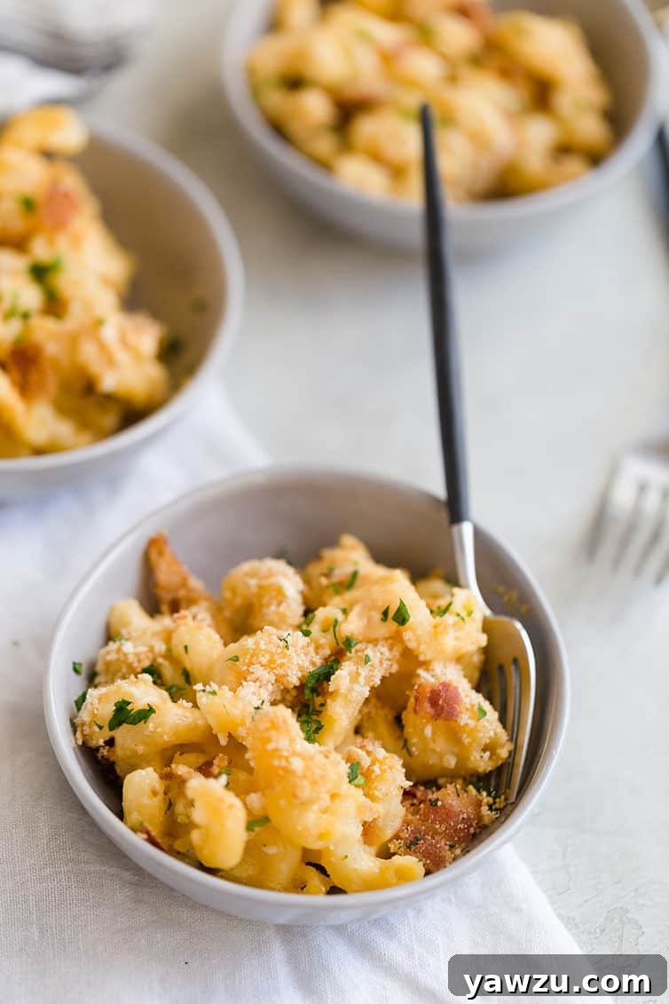 Three individual bowls of baked mac and cheese, showcasing the golden-brown, crispy topping and creamy interior.