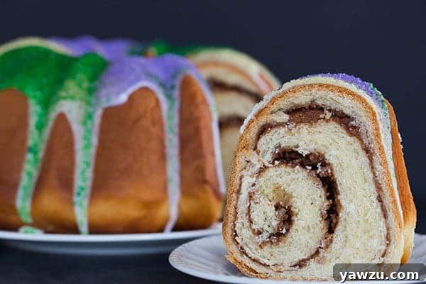 A festive King Cake for Mardi Gras - filled with a pecan, brown sugar and cinnamon swirl - baked into a Bundt pan and decorated with colored sanding sugars, ready to be served.