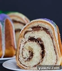 A festive King Cake for Mardi Gras - filled with a pecan, brown sugar and cinnamon swirl - baked into a Bundt pan and decorated with colored sanding sugars.