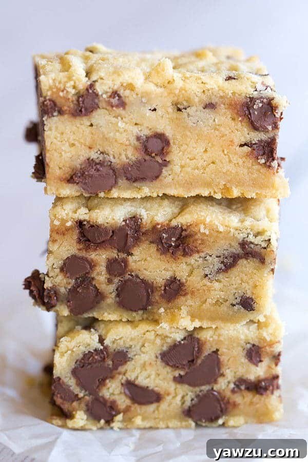 A close-up of the chewy texture and generous chocolate chips in a fresh cookie bar.