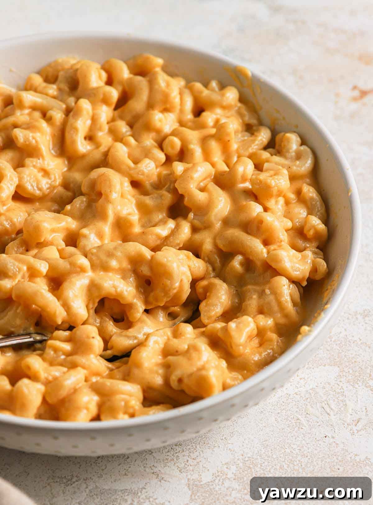 Close up photo of a bowl of stovetop mac and cheese, showcasing its rich, creamy texture.