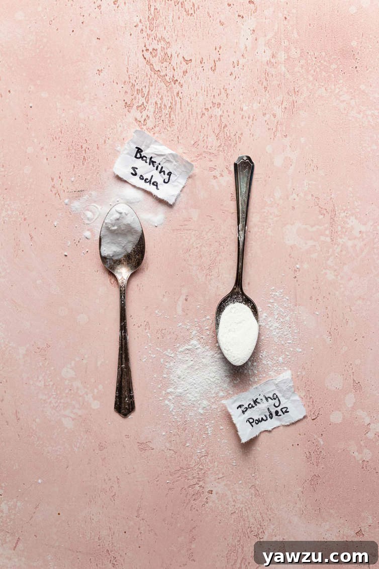 A spoon holding baking powder and a spoon holding baking powder.