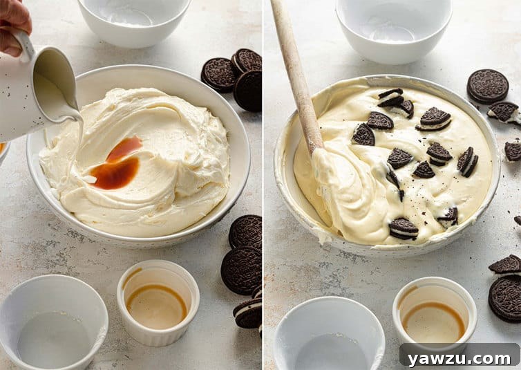 A rubber spatula gently folding chopped Oreo cookie pieces into a creamy cheesecake batter in a large mixing bowl, preparing the filling for the dessert.