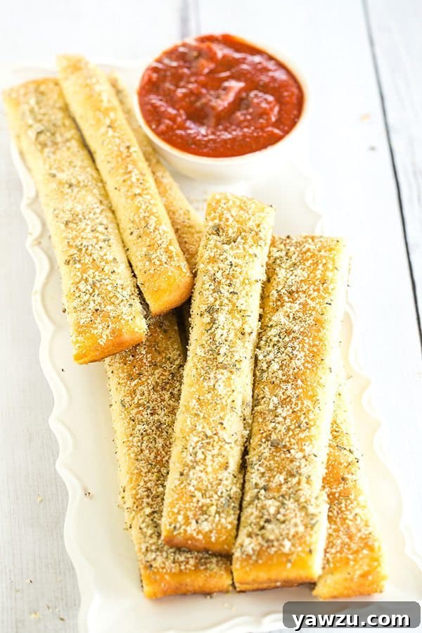 Golden-brown homemade Pizza Hut breadsticks fresh out of the oven, covered in garlic and herb seasoning.