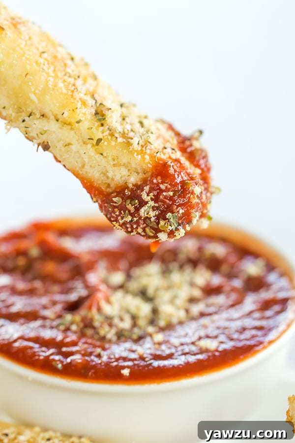 Delicious, warm homemade breadsticks arranged in a pan, showcasing their soft interior and crispy exterior.