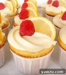 Lemon Limoncello cupcakes topped with creamy frosting, a lemon slice, and a raspberry, ready to serve.