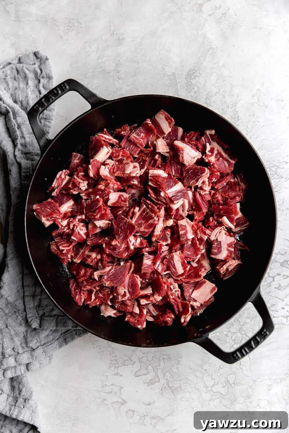 Close-up of perfectly sliced ribeye steak, ready to be cooked for Philly cheesesteaks, showing its rich marbling.