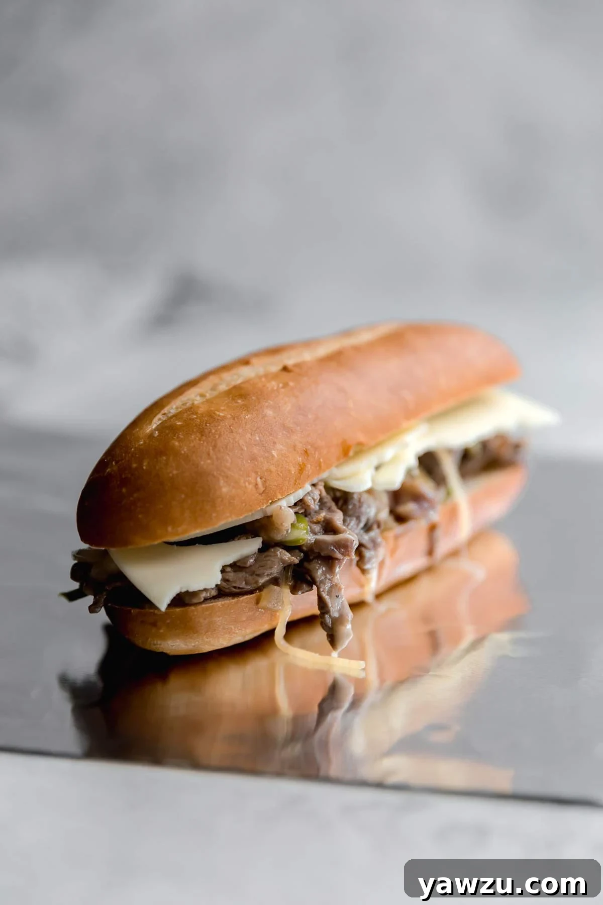 A vibrant spread of Philly cheesesteak sandwiches and an array of delicious side dishes, including french fries, onion rings, and macaroni salad.