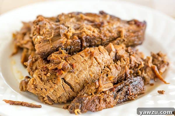 A close-up of tender Slow Cooker BBQ Brisket with rich barbecue sauce.