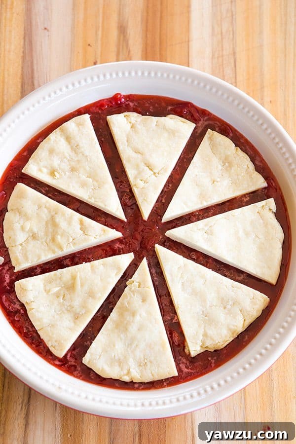 A slice of warm strawberry biscuit cobbler served in a bowl, showing the fluffy biscuit and rich jam.
