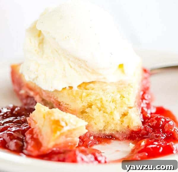 A wide shot of the baked strawberry cobbler in a pie dish, on a wooden surface.