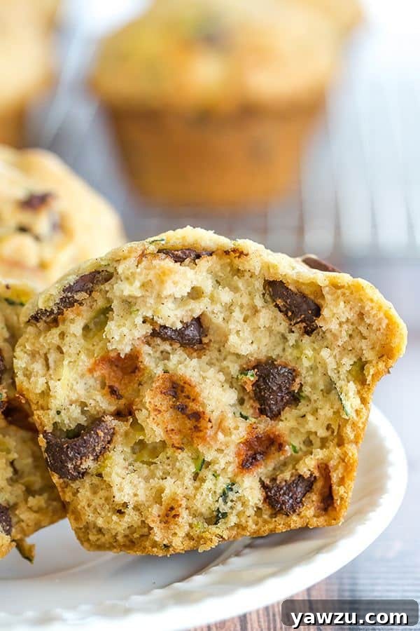 Pile of homemade zucchini chocolate chip muffins on a cooling rack