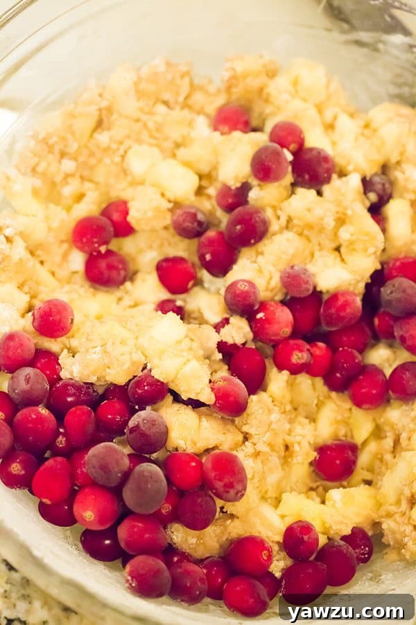 A close-up shot of a baked loaf of Apple Cranberry Bread, showcasing its golden-brown crust and the delicious texture within.