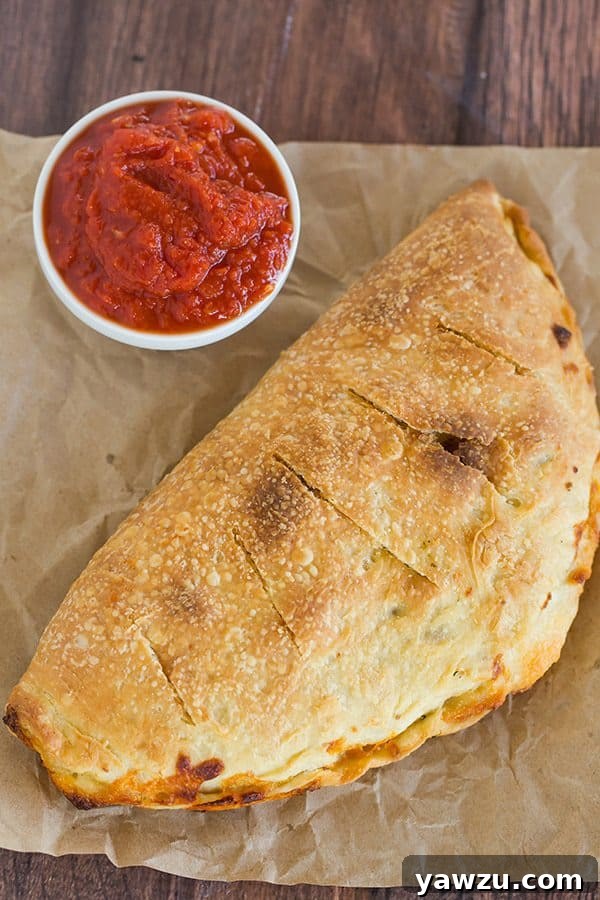Golden-brown homemade calzone cooling on a rack, ready to be enjoyed
