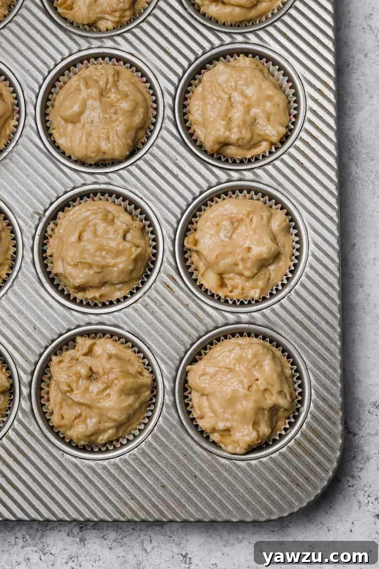 Apple muffin batter in muffin pan.