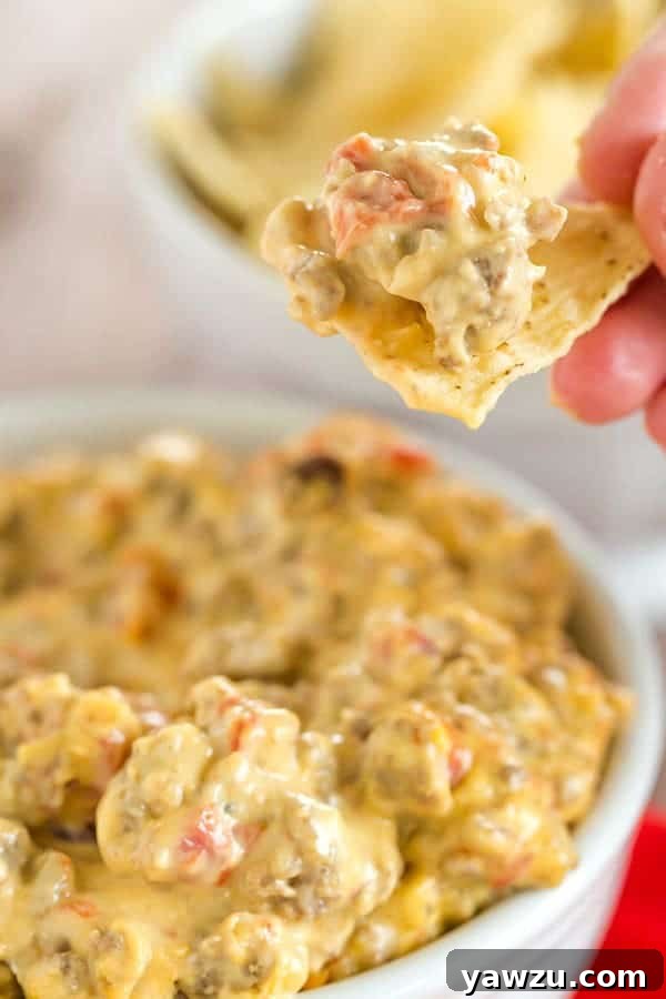 A close-up of the bubbling, cheesy slow cooker dip, garnished with fresh cilantro and ready to be served with tortilla chips. Perfect for game day parties.