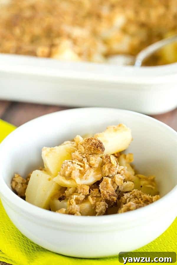 Close-up of golden brown, bubbling pear crisp with a crunchy oat topping, fresh from the oven, ready to serve
