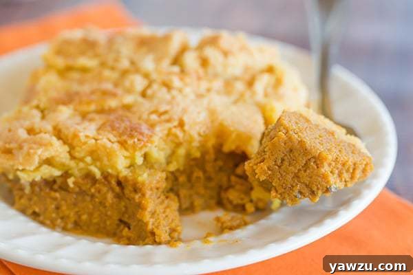 A serving of Pumpkin Yummy Dessert, topped generously with whipped cream, ready to be savored.