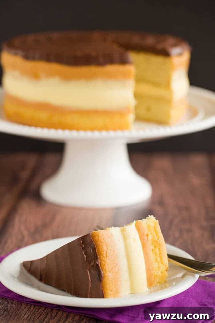 A beautifully presented Boston Cream Pie, ready to be served, showcasing its elegant layers and rich chocolate top.