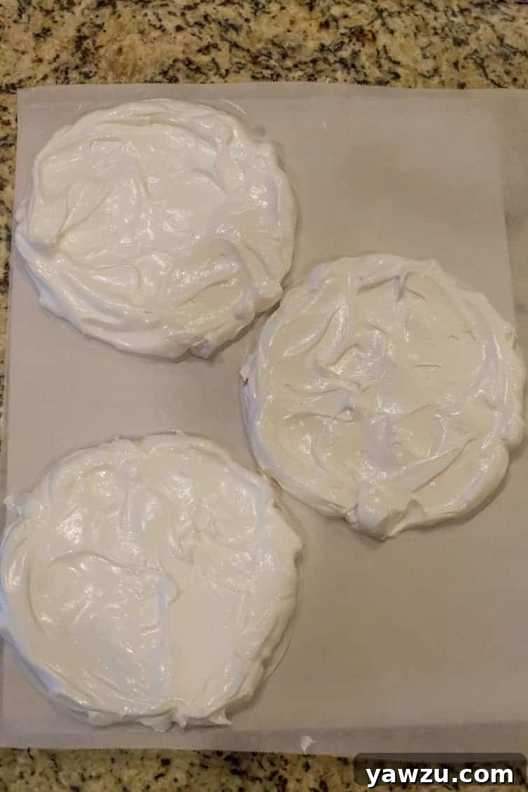 Circles of meringue precisely shaped and ready for baking into pavlova layers.