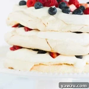 A closeup of pavlova layer cake on a cake stand, highlighting its delicious layers.