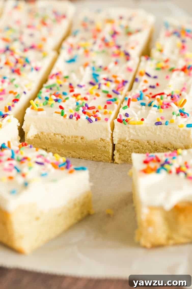 A baking pan filled with freshly baked sugar cookie bars, perfectly sliced into uniform squares, ready for frosting.