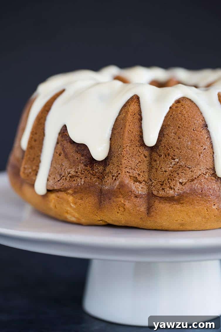 Cinnamon Coffee Cake baked in a Bundt pan, covered in cream cheese icing.