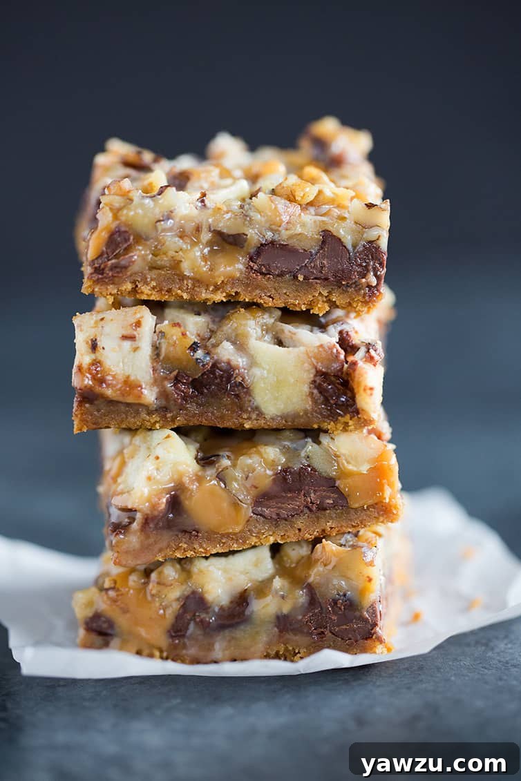 A stack of four golden-brown caramel apple magic bars, showcasing their distinct layers.