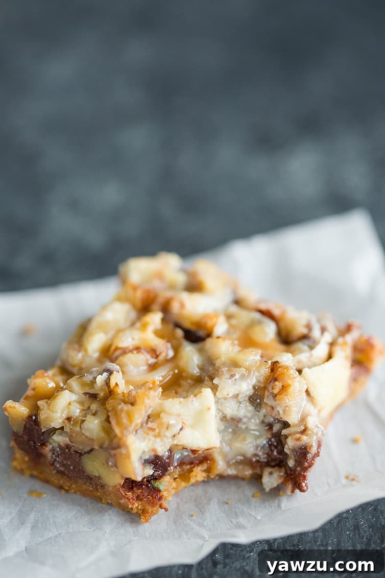 A single caramel apple magic bar with a corner bite removed, showing its chewy interior.