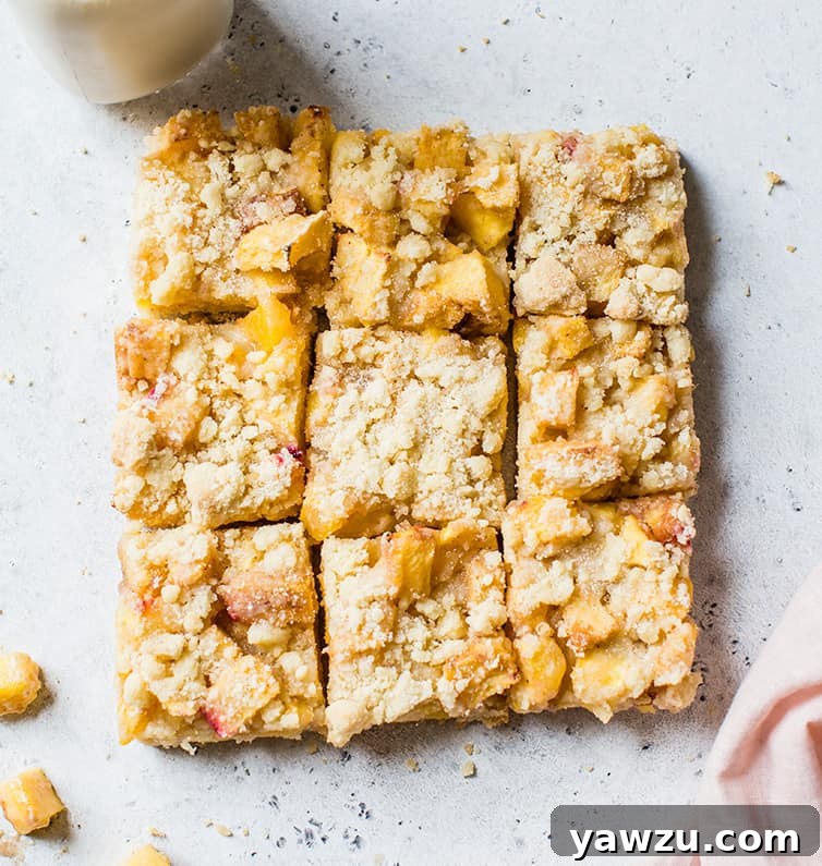 Golden-baked peach crumb bars cut into perfect squares, ready to be enjoyed.