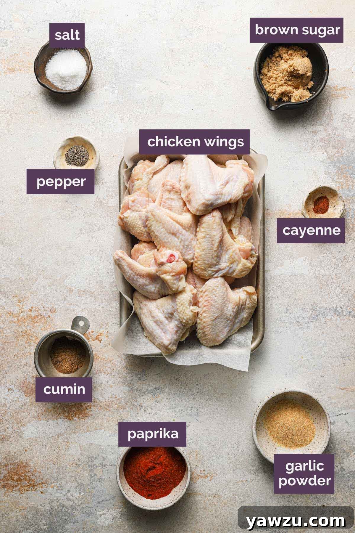 Individual ingredients for crispy baked chicken wings laid out and clearly labeled on a kitchen counter.