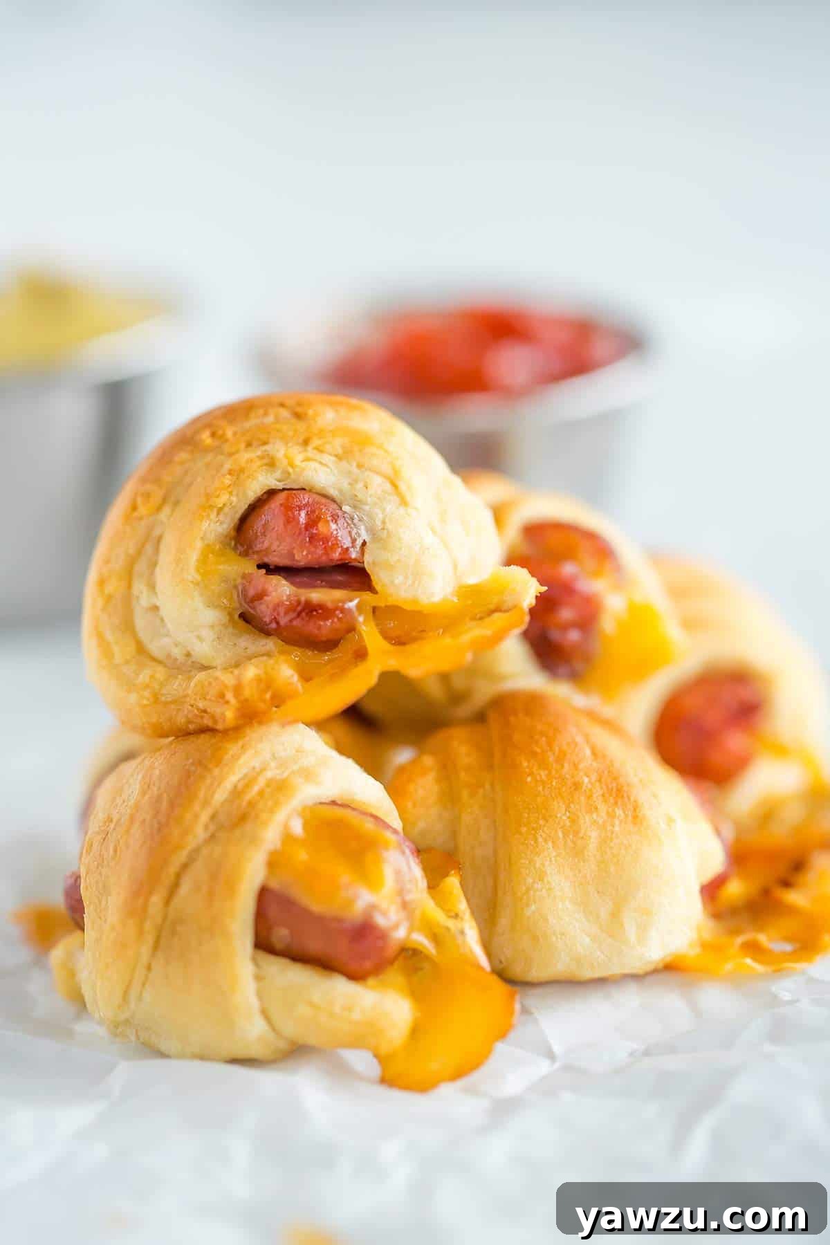 A stack of cheesy pigs in a blanket, freshly baked and ready to eat.