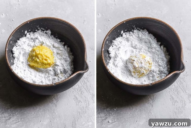 Rolling balls of lemon cookie dough in powdered sugar before baking for the crinkle effect.