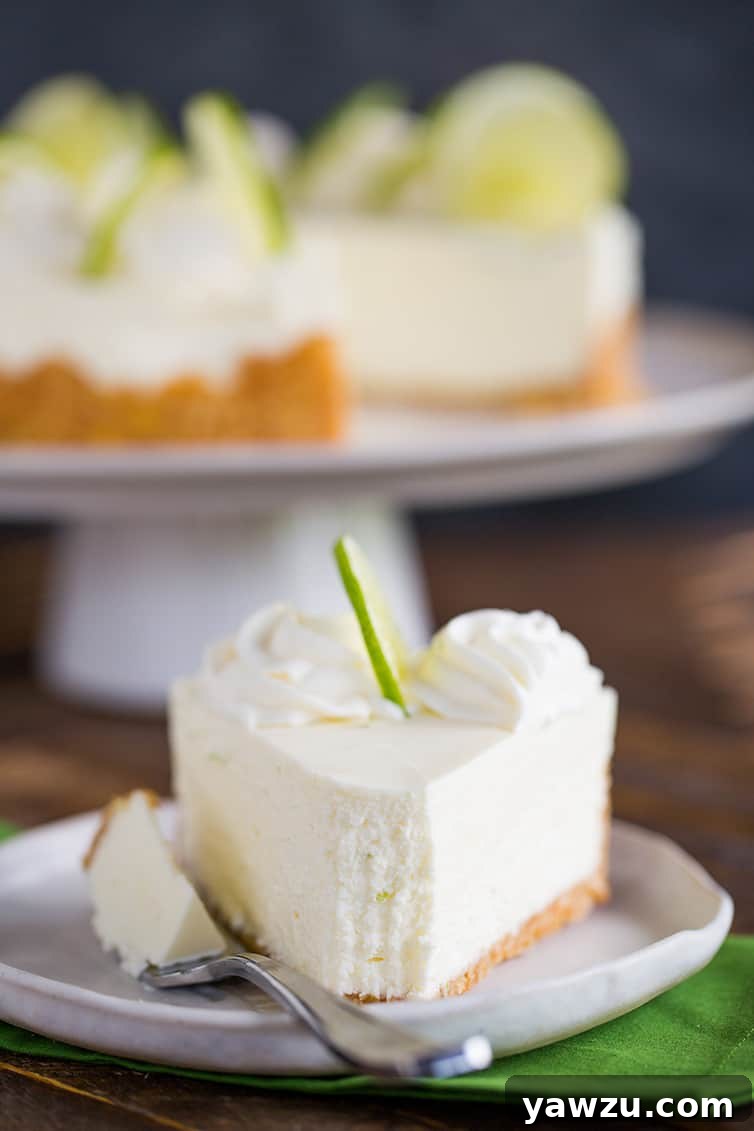 A slice of key lime cheesecake with a forkful taken out. 