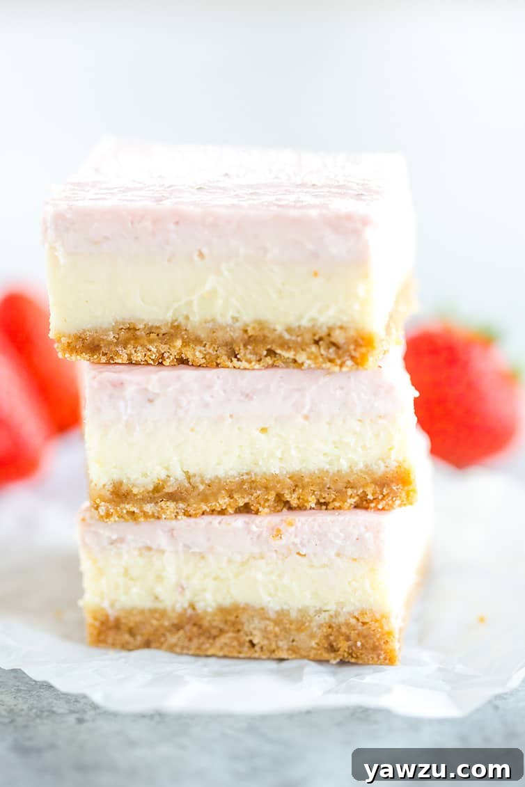 Three strawberry cheesecake bars stacked on top of each other, showcasing the distinct layers.