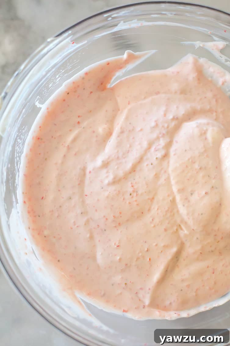 Close-up of the bright and inviting strawberry-sour cream topping for strawberry cheesecake bars.