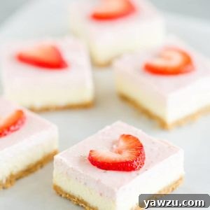 Five strawberry cheesecake bars on a piece of parchment paper.
