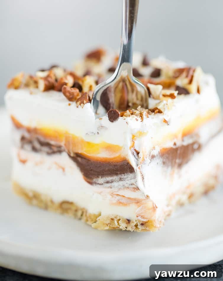 A fork going through a piece of chocolate lush dessert, showcasing its multiple layers.