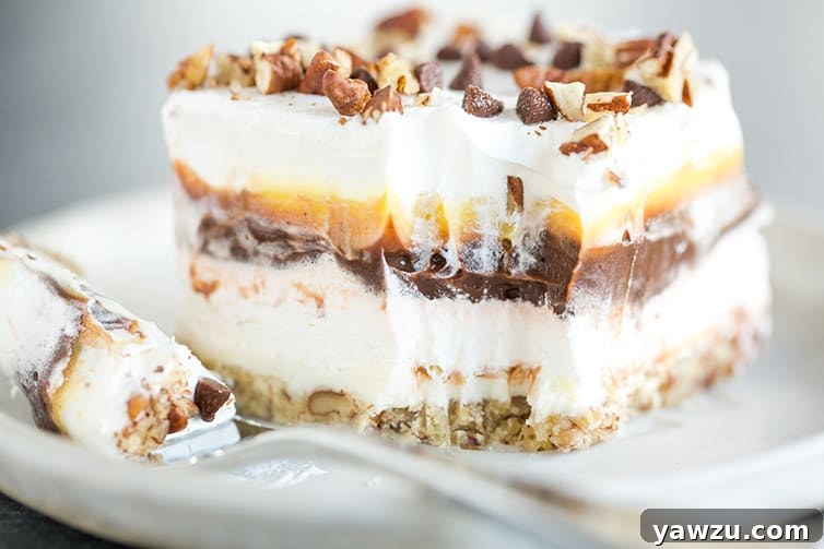 A piece of chocolate lush dessert on a plate with a forkful already taken out, revealing the soft interior.