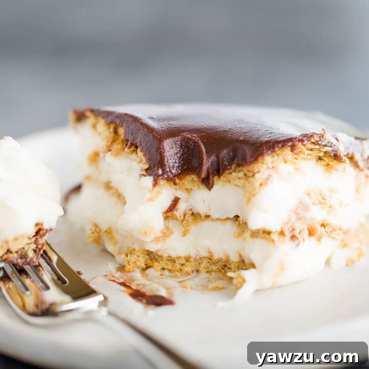 A piece of chocolate eclair cake with a forkful taken out of it.