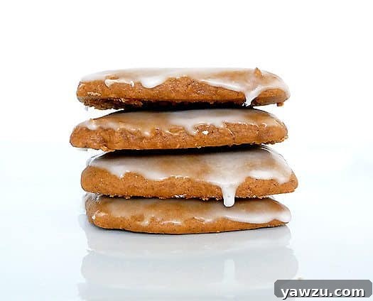 Stack of 4 glazed lebkuchen cookies on a white plate.